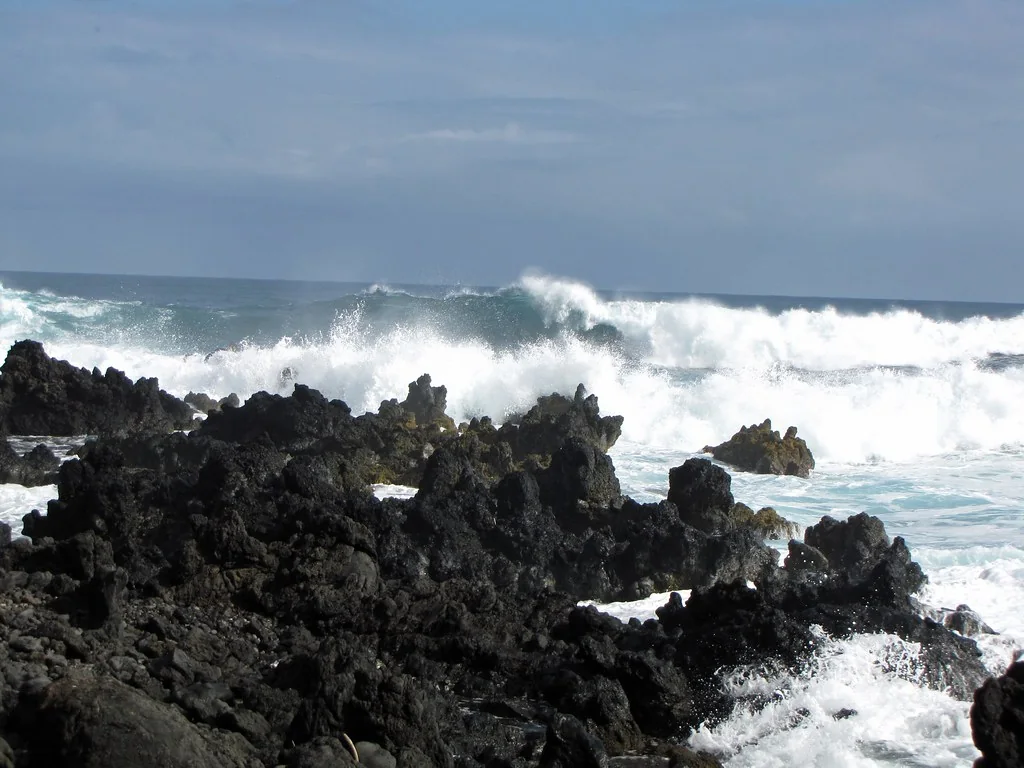 White surf breaks against black lava rock on the Hawai'i coast