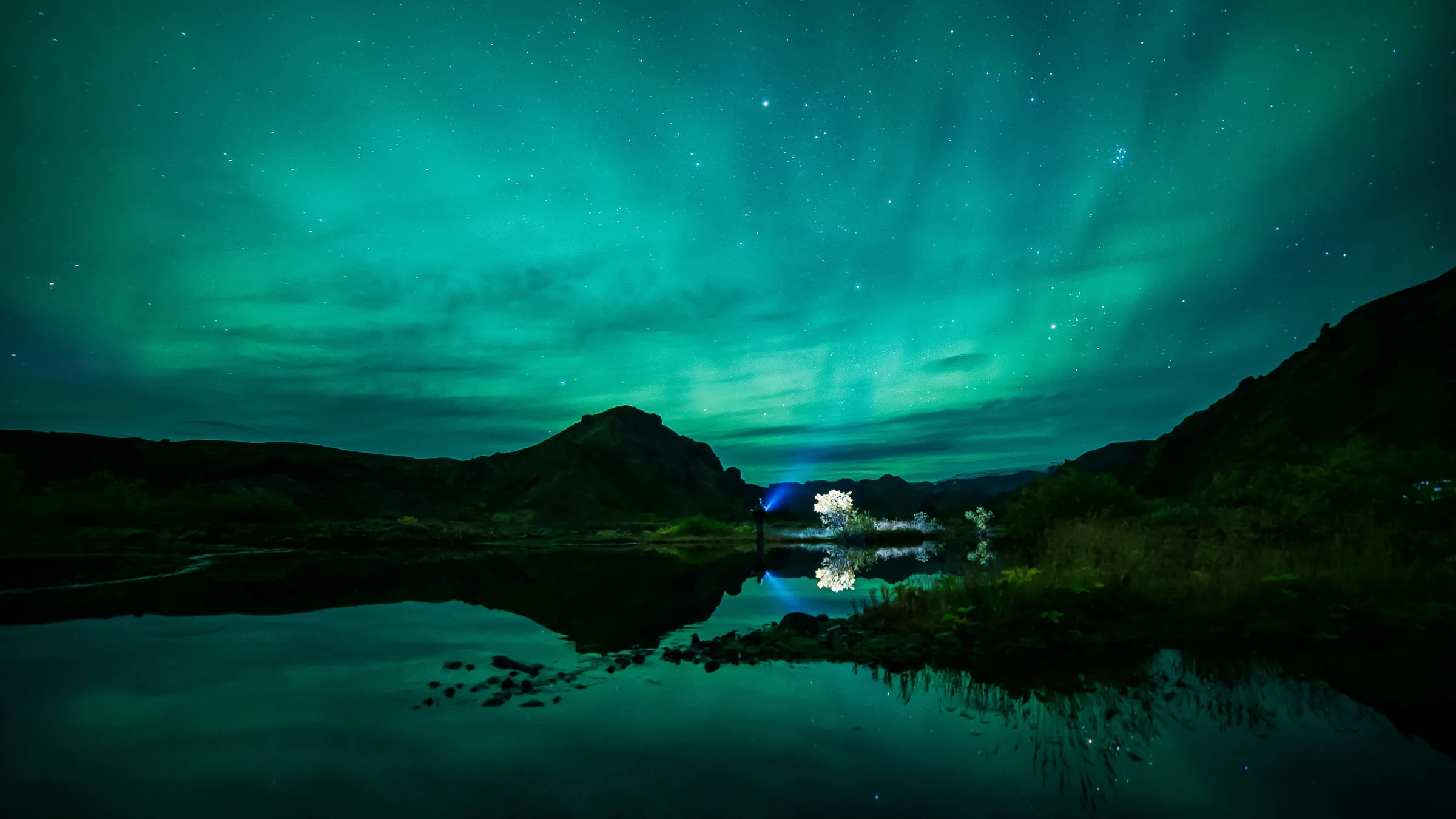 Aurora reflected in still water at Stakkholtsgjá, Iceland